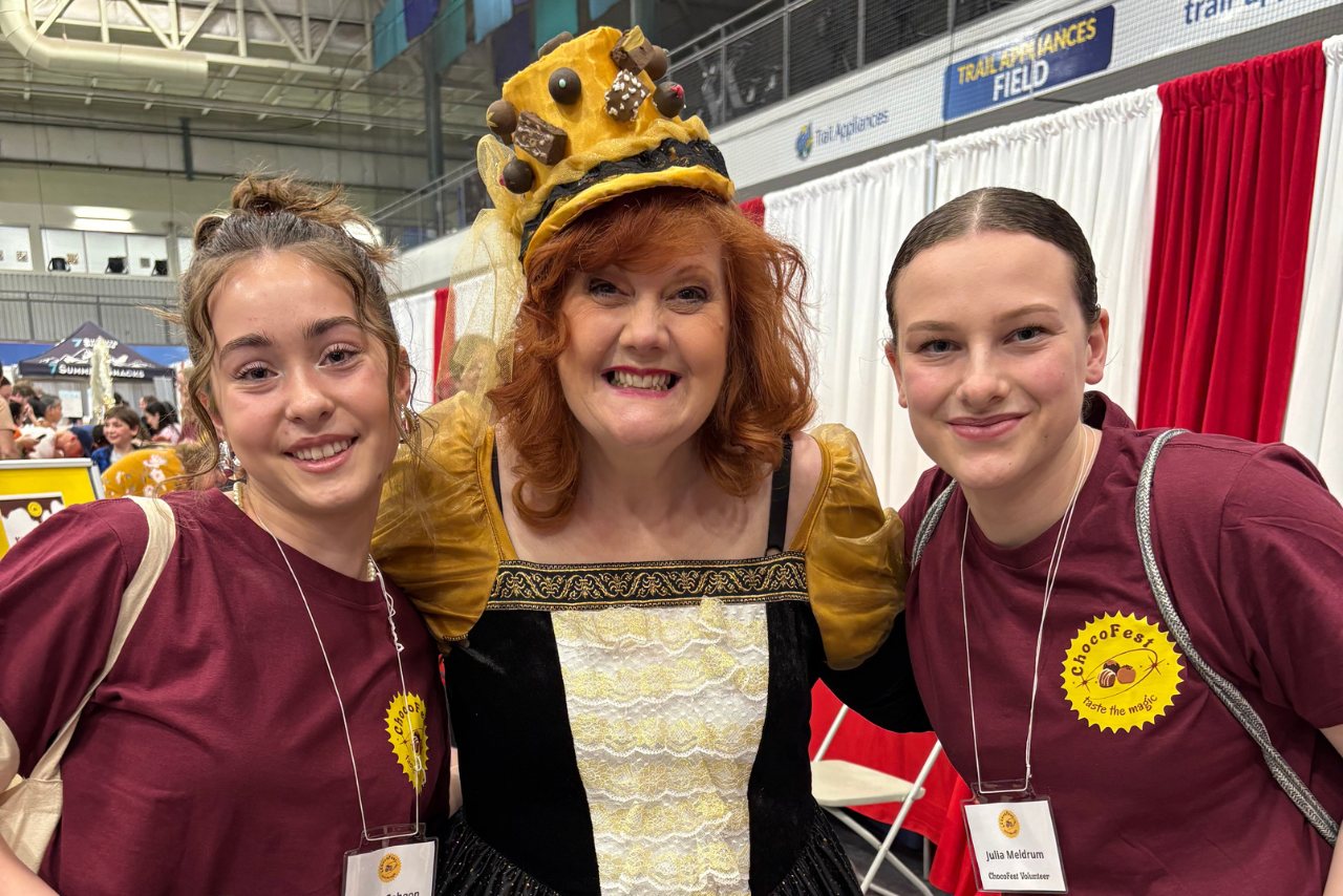Smiling volunteers at ChocoFest posing with Madam Chocolala.